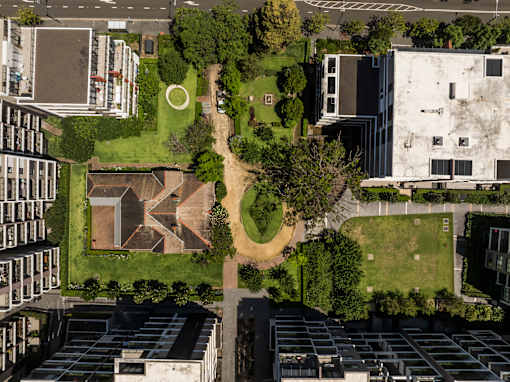 A large building complex with a green space in the middle.