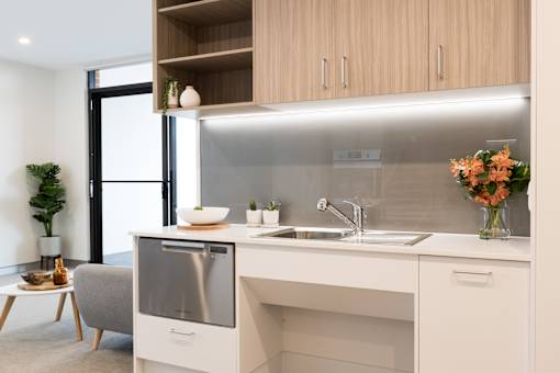 A modern kitchen with a stainless steel oven and a white countertop.
