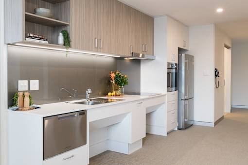 A modern kitchen with a stainless steel dishwasher and refrigerator.