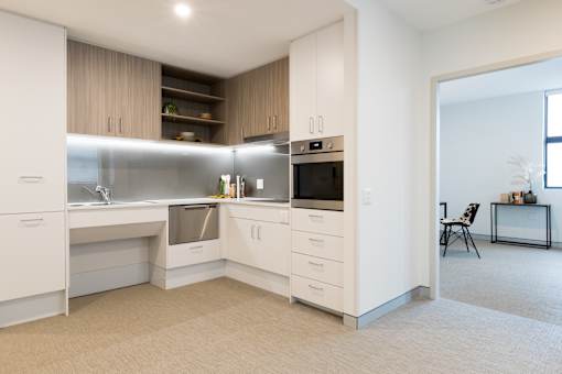 A modern kitchen with white cabinets and appliances.
