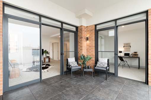 A modern interior with a glass door and a brick wall.