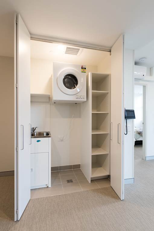 A small kitchen with a sink and a fridge.