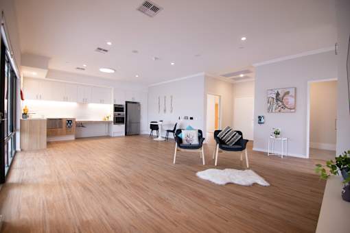 A modern living room with a white rug and a black chair.