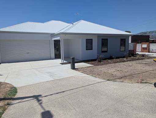 A white house with a grey roof and a grey garage door.