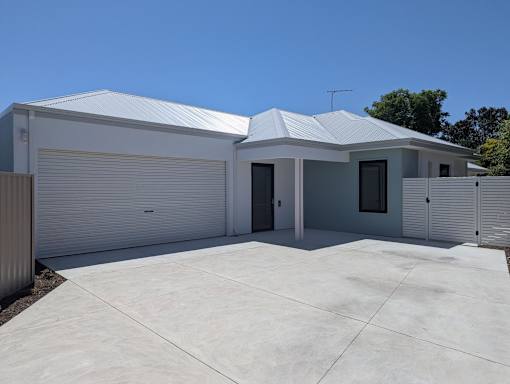 A two-story house with a garage door and a driveway.