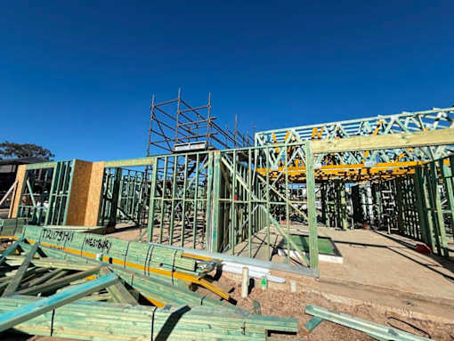 A construction site with a large metal framework and wooden beams.