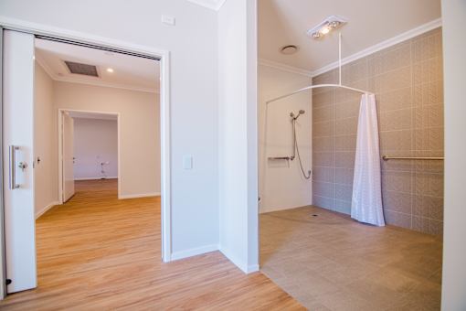 A bathroom with a walk-in shower and a towel rack.
