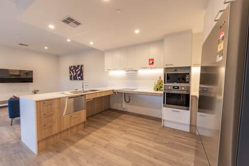 A modern kitchen with wooden cabinets and stainless steel appliances.