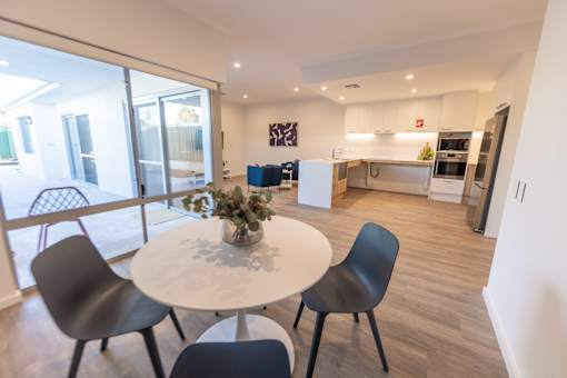 A dining area with a white table and chairs.