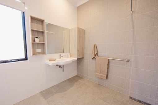 A bathroom with a sink and a towel hanging on the shower rod.