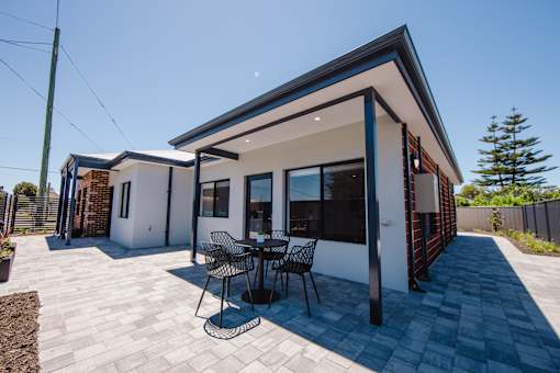 A modern house with a patio and outdoor furniture.
