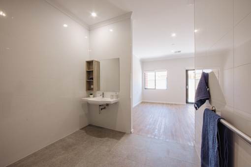 A bathroom with a sink, mirror, and tiled floor.