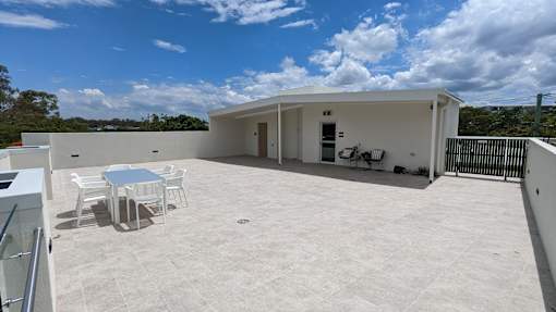A white building with a table and chairs outside.