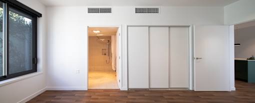 A room with a white door and a window on the left.