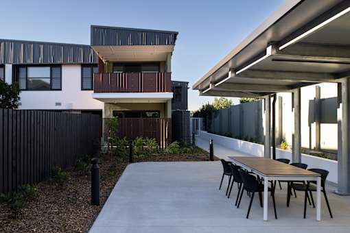 A modern house with a patio and dining table.