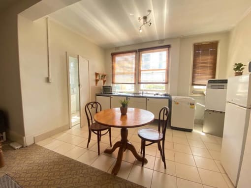 a kitchen with a table and a refrigerator and a sink