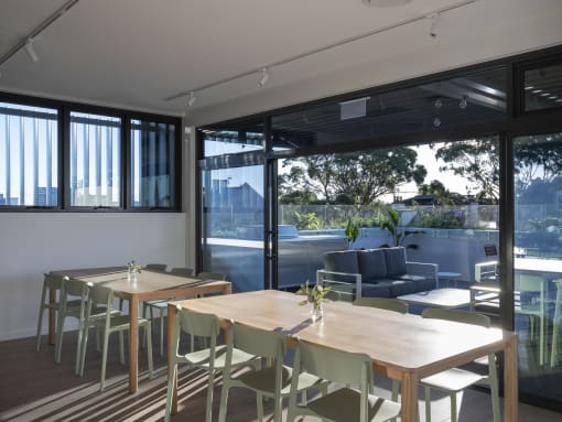 a dining room with tables and chairs and sliding glass doors