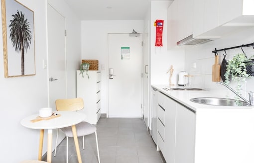 a white kitchen with a table and a sink