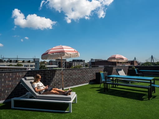 a woman sitting on a lounge chair on a roof top