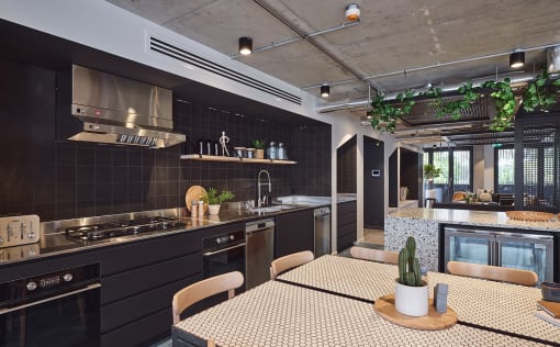 a kitchen with black cabinets and a table and chairs