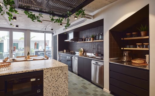 a kitchen with black cabinets and stainless steel appliances