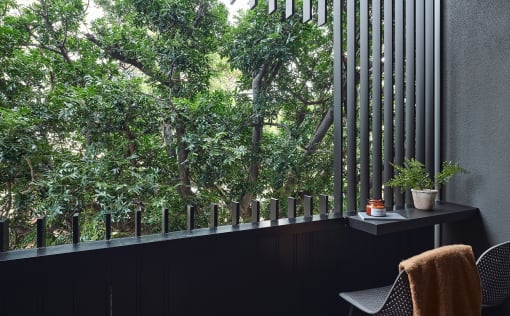 a balcony with a view of trees and a table and chairs