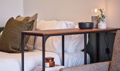 a bed with a wooden table on top of it