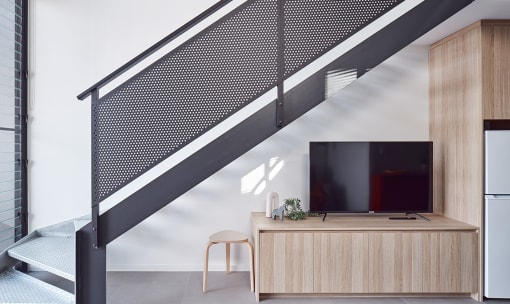 a wooden cabinet under a staircase with a television on it