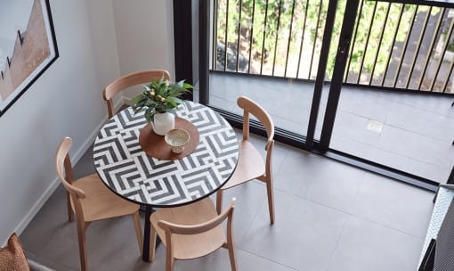 a dining area with a table and chairs and a window