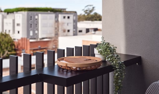 a balcony with a wooden table and a view of buildings