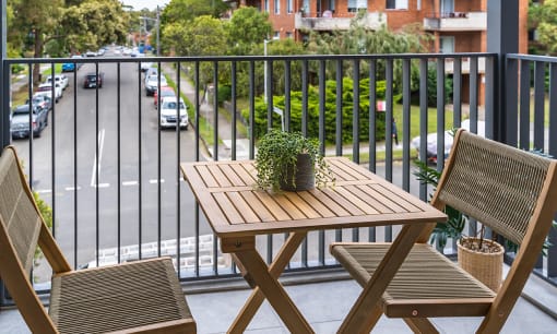 a table and chairs on a balcony overlooking a city street