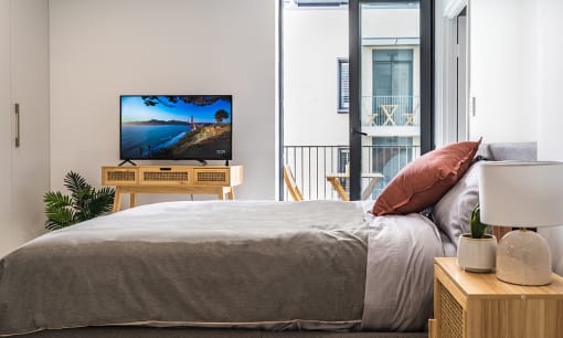 a bedroom with a bed and a tv in a room