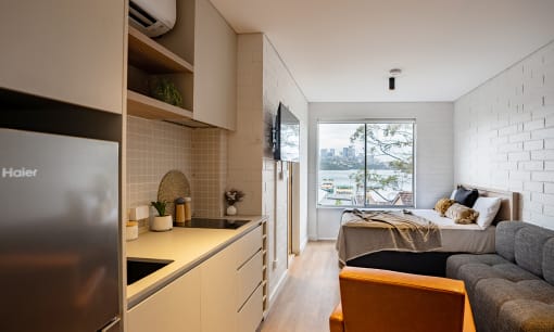 a small apartment with a bed and a kitchen
