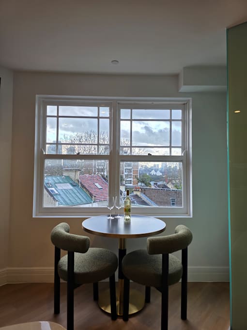 A window with a view of a building and trees outside.