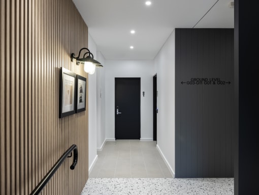 a corridor with a black door and a white tiled floor and a black wall