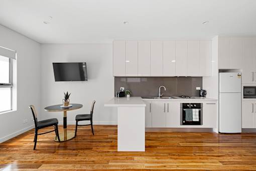 A modern kitchen with a table and chairs in the foreground.