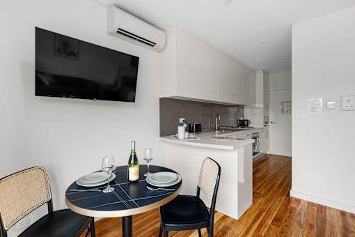 A black table with a bottle of wine and glasses on it.