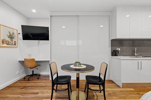 A modern dining room with a round table and chairs.