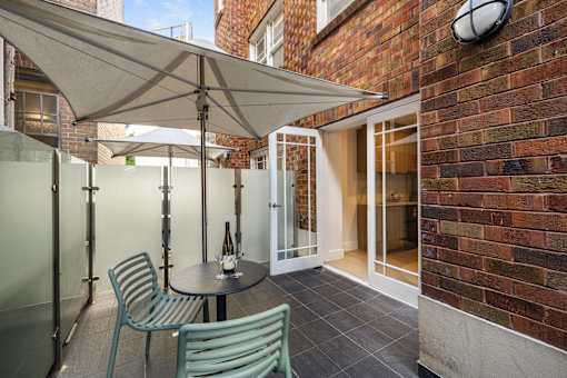 A patio with a table and chairs under a canopy.