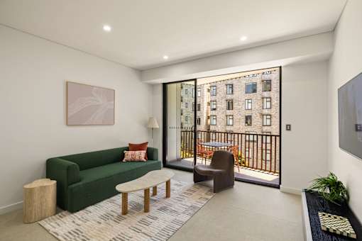 A living room with a green couch, a brown chair, a coffee table, and a painting on the wall.