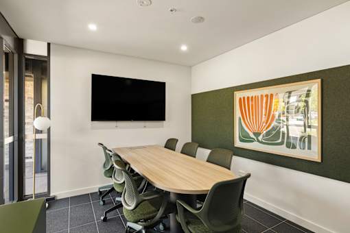 A conference room with a long table and chairs.