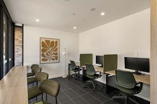 A room with a long table and chairs and a painting on the wall.