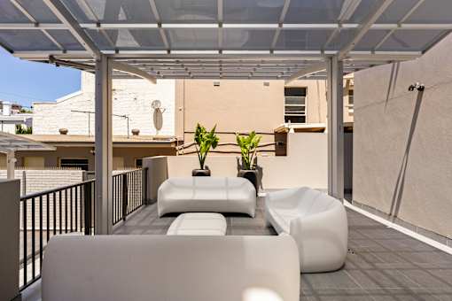 A white patio with a couch and a table.