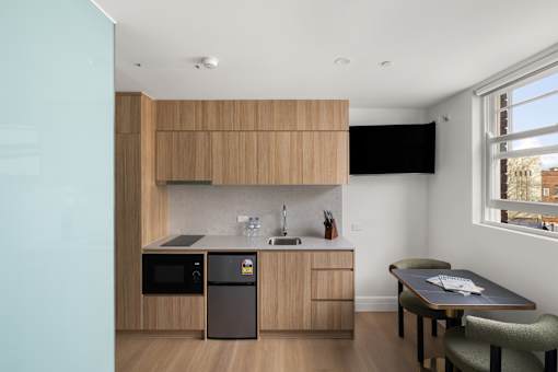 A kitchen with a table and chairs.