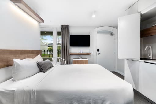 a bedroom with a large white bed and a television