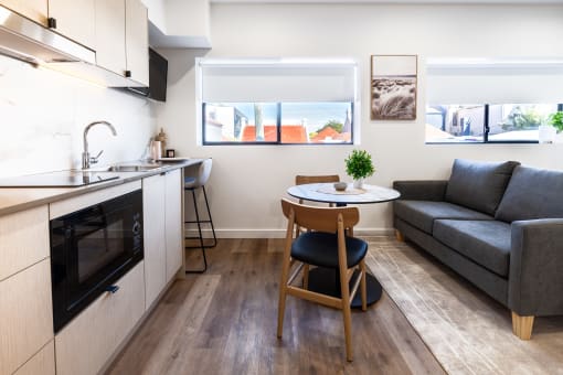 a living room with a kitchen and a couch and a table