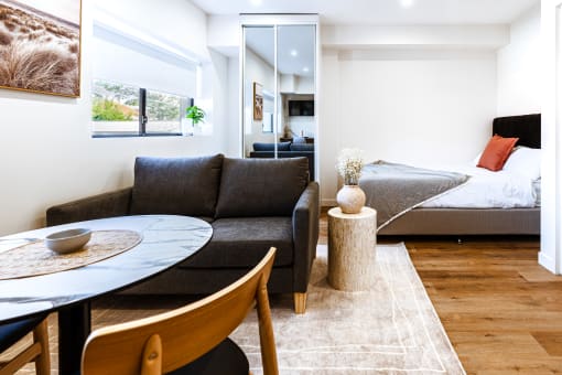 a living room with a couch and a table and a bed