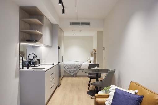 a small apartment with a kitchen and a bed