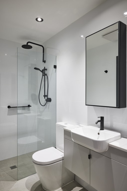 a white bathroom with a shower sink and toilet