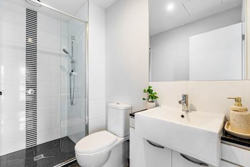 A white toilet sits next to a sink in a modern bathroom.